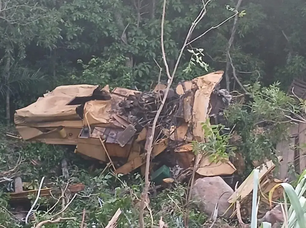 Colheitadeira e caminhão ficaram completamente destruídos após queda em serra. (Foto: Divulgação, Corpo de Bombeiros)